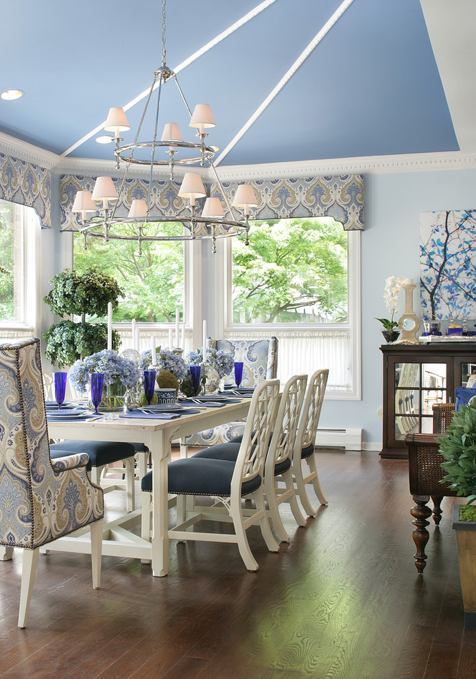 This is an example of a traditional dining room in New York with blue walls and dark hardwood floors.