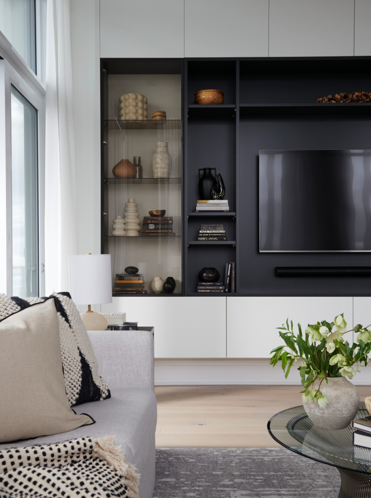 Idée de décoration pour un salon design de taille moyenne et ouvert avec un mur blanc, parquet clair, un téléviseur encastré et un sol marron.