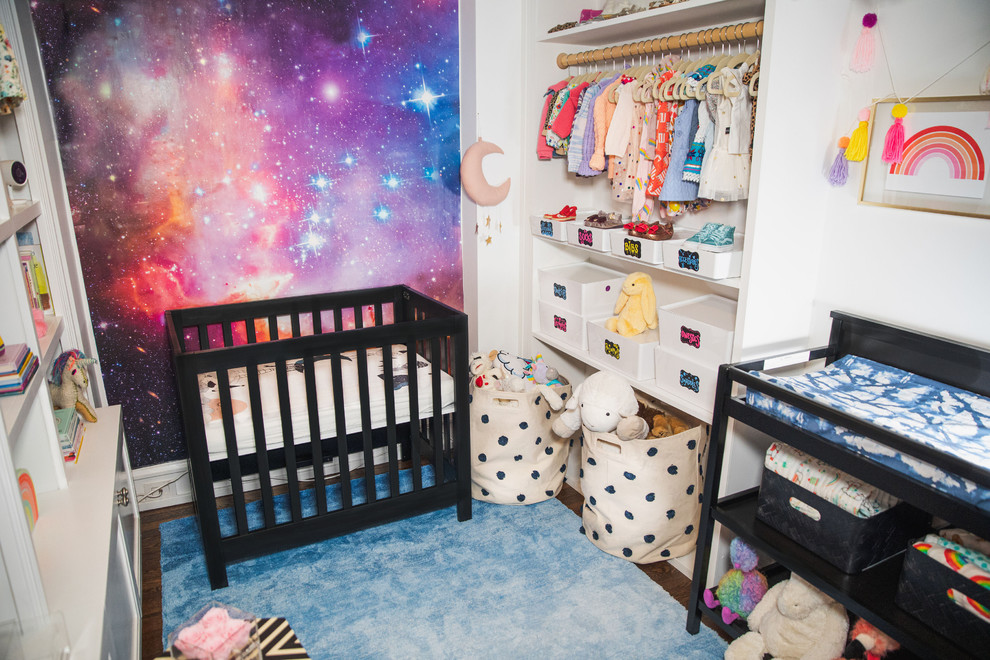 Inspiration for a small modern nursery for girls in New York with white walls, dark hardwood floors and brown floor.