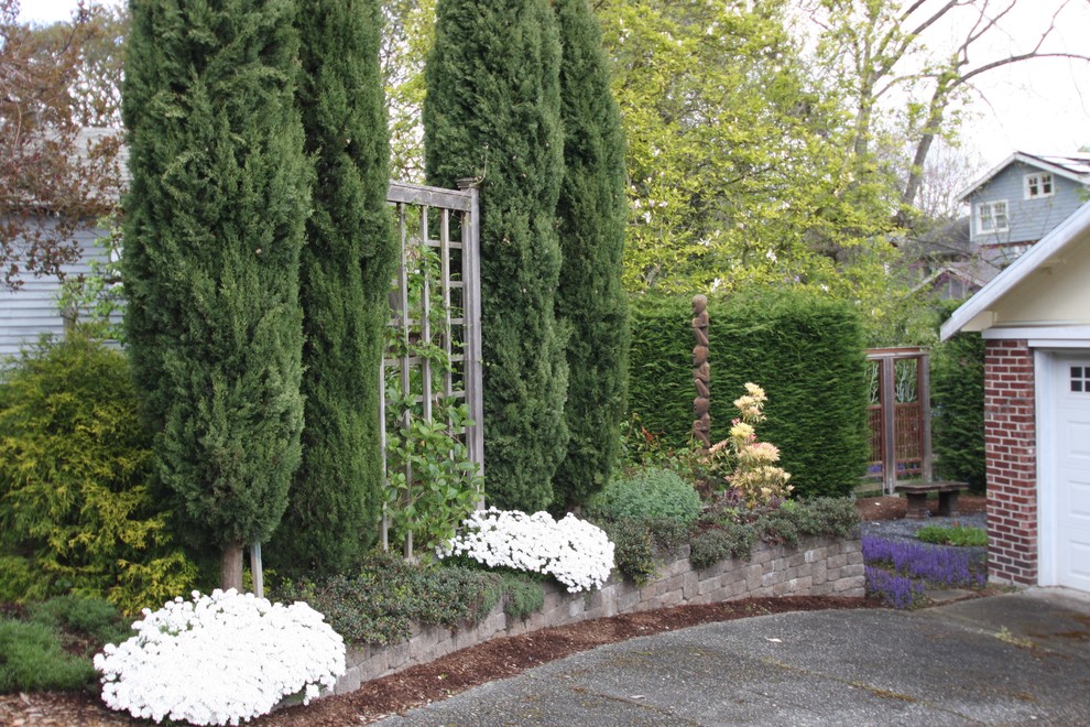 Photo of a small traditional backyard partial sun formal garden in Seattle with with privacy feature and gravel.