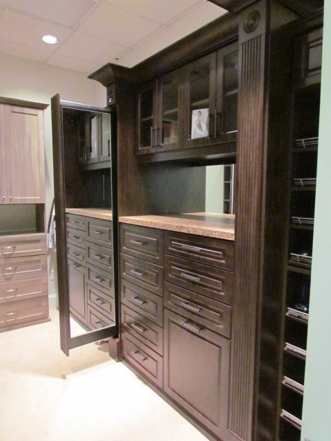 Large traditional gender-neutral dressing room in Atlanta with raised-panel cabinets, dark wood cabinets, carpet and beige floor.