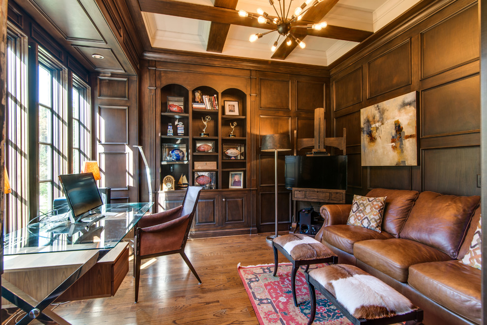 This is an example of a traditional study room in Nashville with brown walls, medium hardwood floors and a freestanding desk.