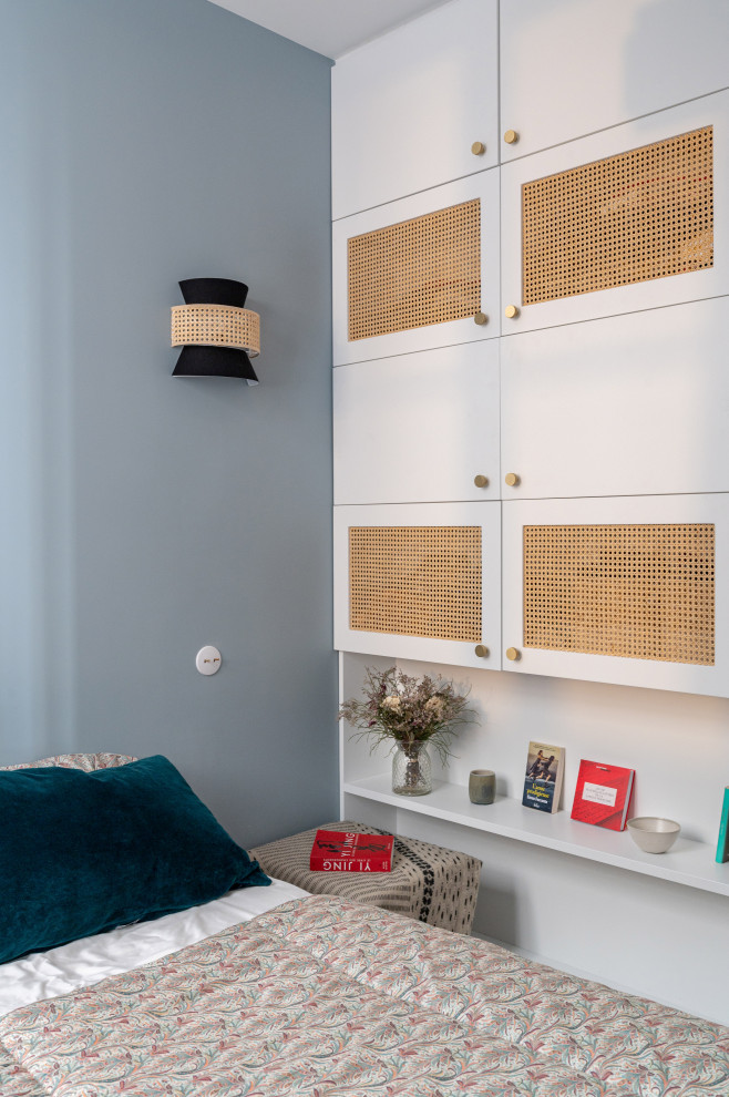 Cette photo montre une petite chambre parentale tendance avec un mur bleu et parquet clair.