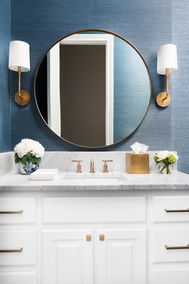 Photo of a transitional powder room in Austin with raised-panel cabinets, white cabinets, blue walls, an undermount sink, marble benchtops and grey benchtops.