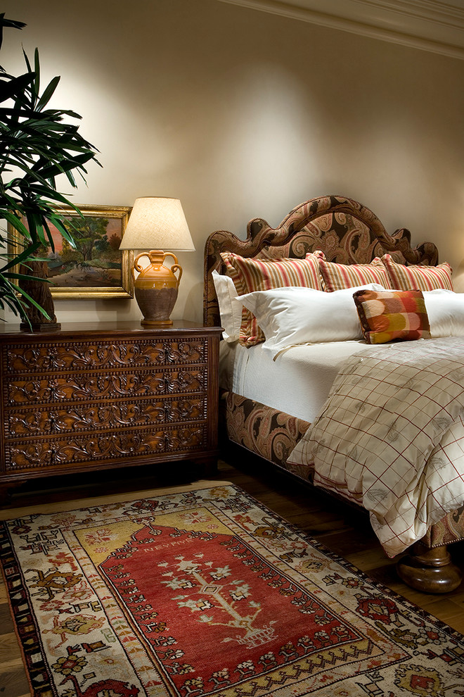 Mediterranean bedroom in Phoenix with beige walls and dark hardwood floors.