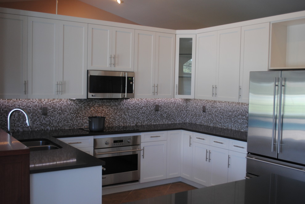 Kitchen pantry - mid-sized transitional u-shaped ceramic tile kitchen pantry idea in Miami with an undermount sink, shaker cabinets, white cabinets, quartzite countertops, metallic backsplash, glass tile backsplash, stainless steel appliances and an island