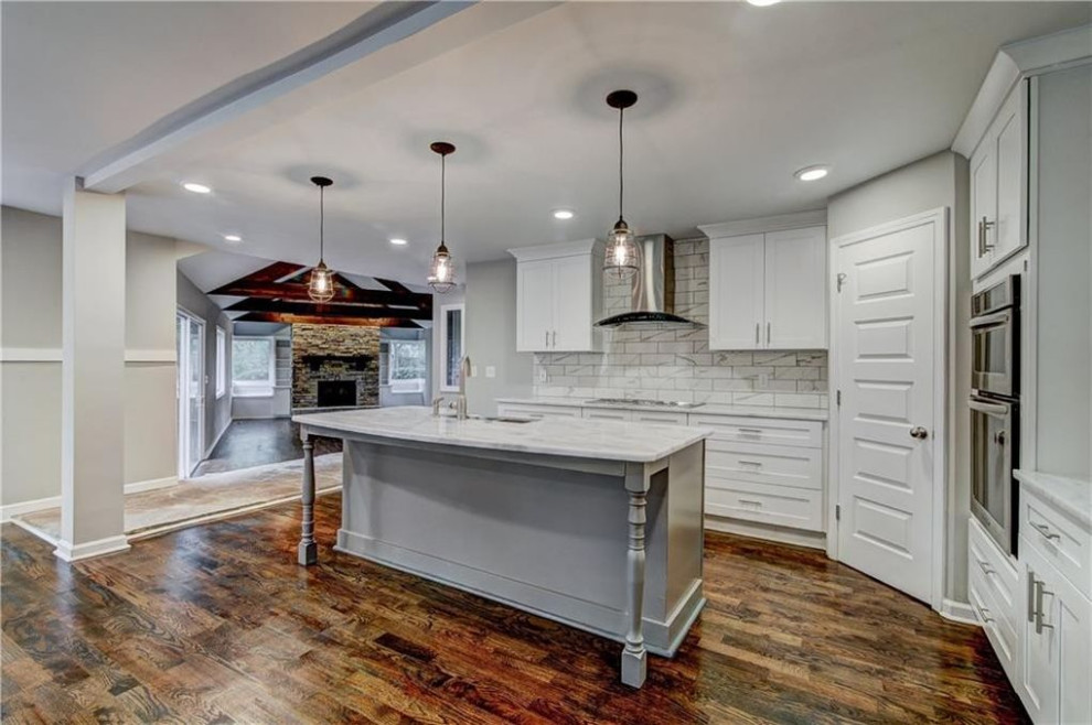 This is an example of a mid-sized traditional kitchen pantry in Atlanta with a single-bowl sink, shaker cabinets, white cabinets, tile benchtops, grey splashback, porcelain splashback, stainless steel appliances, medium hardwood floors, with island, brown floor, grey benchtop and wood.