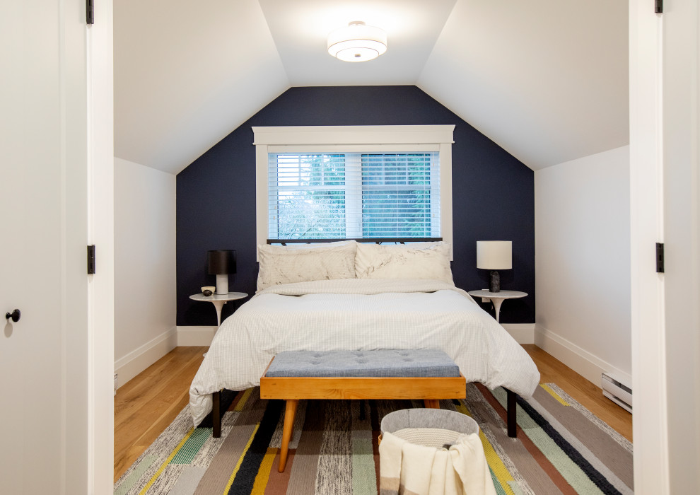 Design ideas for a transitional bedroom in Vancouver with blue walls, medium hardwood floors, brown floor and vaulted.
