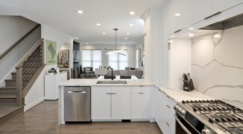 Inspiration for a mid-sized modern l-shaped medium tone wood floor and gray floor open concept kitchen remodel in DC Metro with a single-bowl sink, flat-panel cabinets, white cabinets, quartz countertops, white backsplash, quartz backsplash, stainless steel appliances, a peninsula and white countertops
