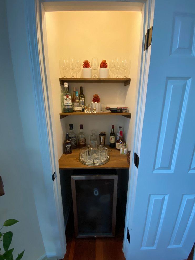 Ispirazione per un piccolo angolo bar tradizionale con mensole sospese, ante marroni, top in legno e top marrone