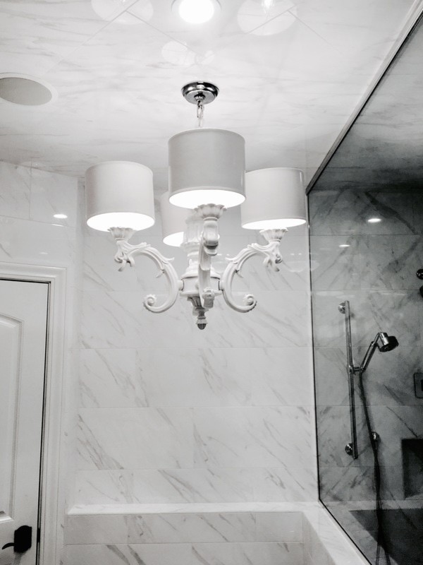 Inspiration for a large transitional white tile and porcelain tile marble floor claw-foot bathtub remodel with white cabinets, a one-piece toilet, white walls, an undermount sink and marble countertops