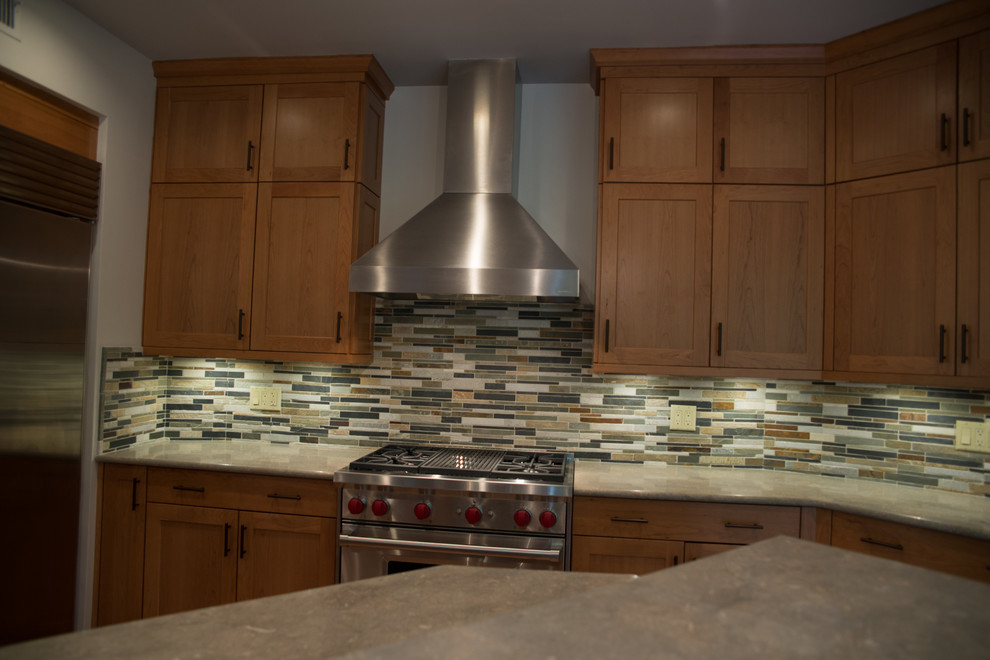 Inspiration for a large transitional l-shaped medium tone wood floor eat-in kitchen remodel with a double-bowl sink, recessed-panel cabinets, medium tone wood cabinets, concrete countertops, multicolored backsplash, matchstick tile backsplash, stainless steel appliances and an island
