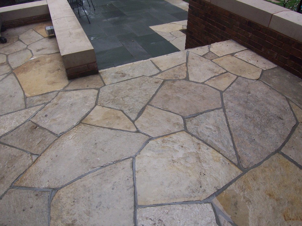 Mid-sized transitional backyard patio in Chicago with natural stone pavers and no cover.