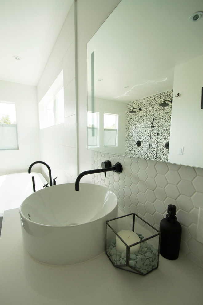Photo of a large contemporary master bathroom in San Diego with furniture-like cabinets, white cabinets, white tile, cement tile, white walls, porcelain floors, granite benchtops, a freestanding tub and an open shower.
