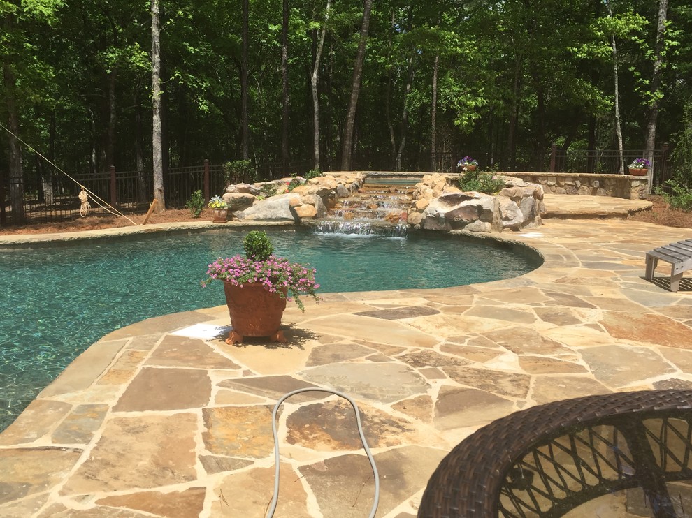 Mid-sized mountain style backyard stone and custom-shaped natural hot tub photo in Atlanta