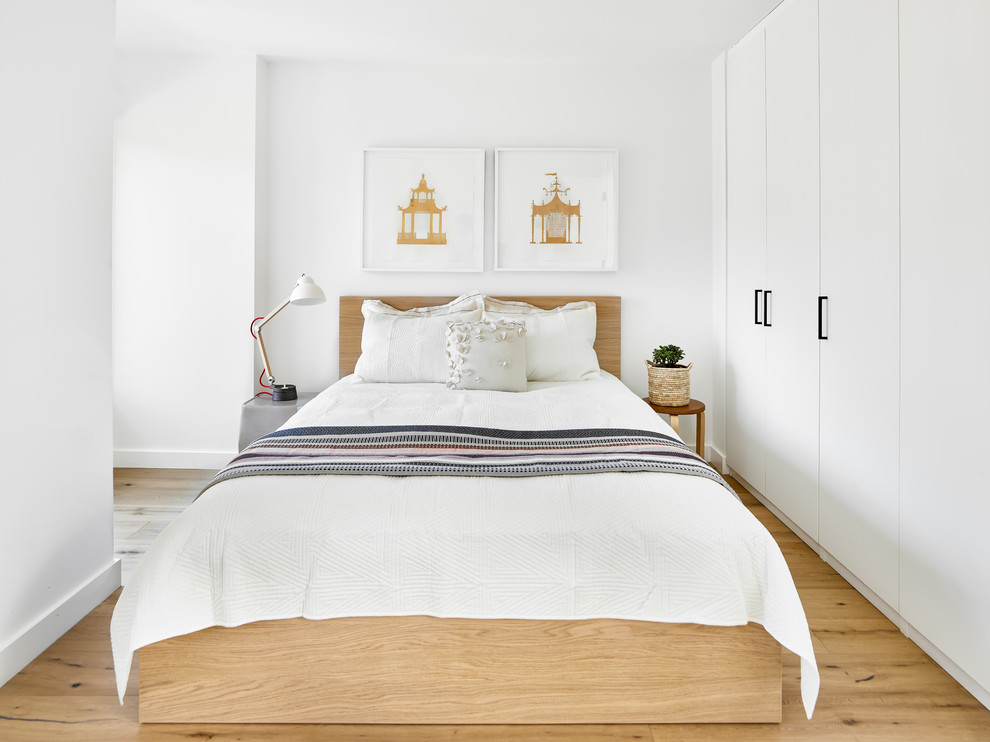 Inspiration for a small contemporary master bedroom in Toronto with white walls, brown floor and medium hardwood floors.