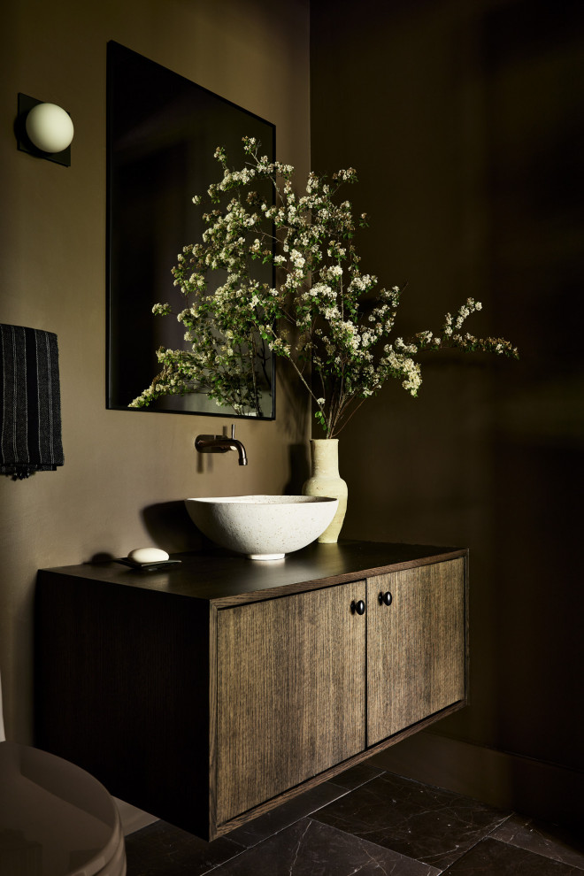 Photo of a small contemporary powder room in Providence with flat-panel cabinets, dark wood cabinets, a one-piece toilet, green walls, marble floors, a vessel sink, wood benchtops, grey floor, brown benchtops and a floating vanity.