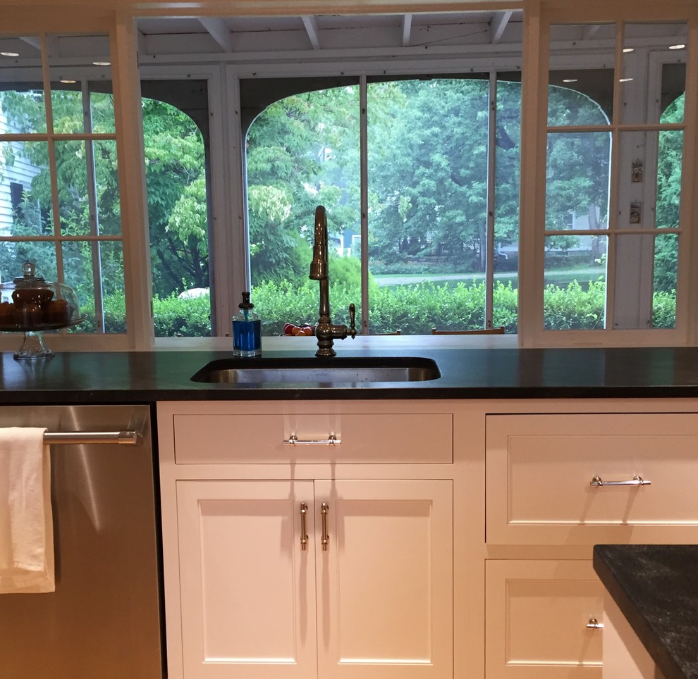 Photo of a large country l-shaped eat-in kitchen in Portland Maine with shaker cabinets, white cabinets, soapstone benchtops, grey splashback, marble splashback, stainless steel appliances, medium hardwood floors, multiple islands and beige floor.