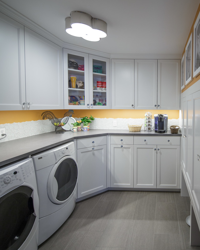 Inspiration for a mid-sized traditional galley utility room in Boston with beaded inset cabinets, white cabinets, laminate benchtops, orange walls, ceramic floors and a side-by-side washer and dryer.