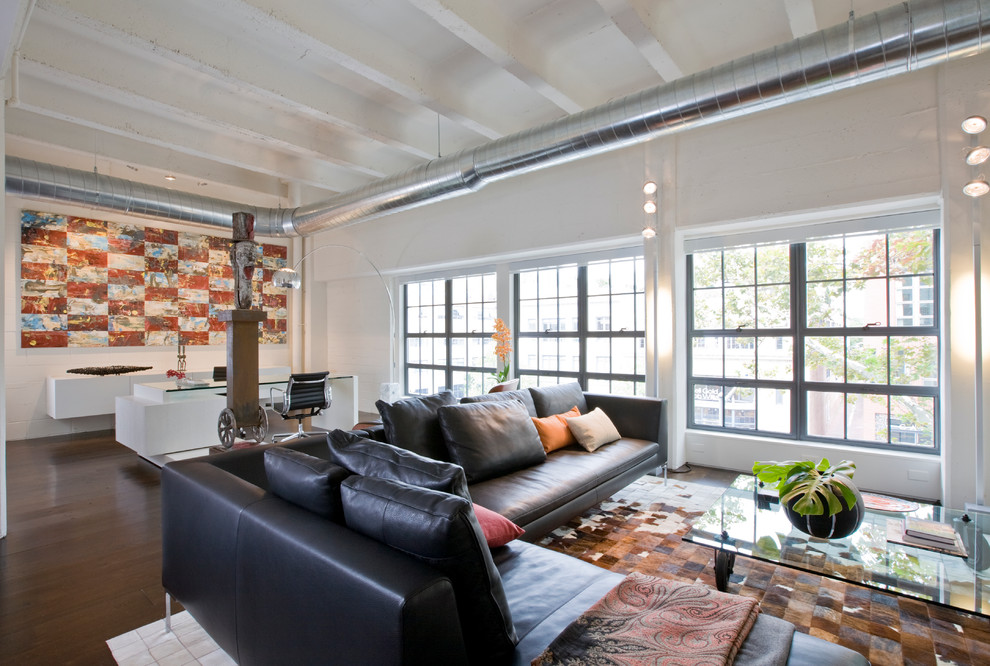 Photo of a large industrial open concept living room in DC Metro with white walls.