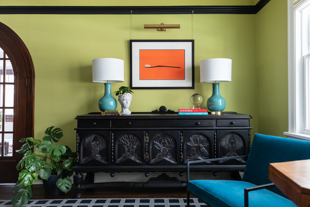 Aménagement d'un salon éclectique avec un mur vert, parquet foncé, une cheminée standard, un manteau de cheminée en brique et un sol marron.
