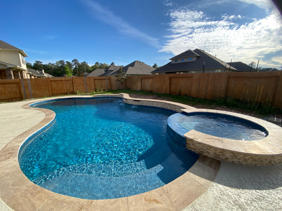 Inspiration for a medium sized classic back kidney-shaped lengths swimming pool in Houston with a water feature and concrete slabs.