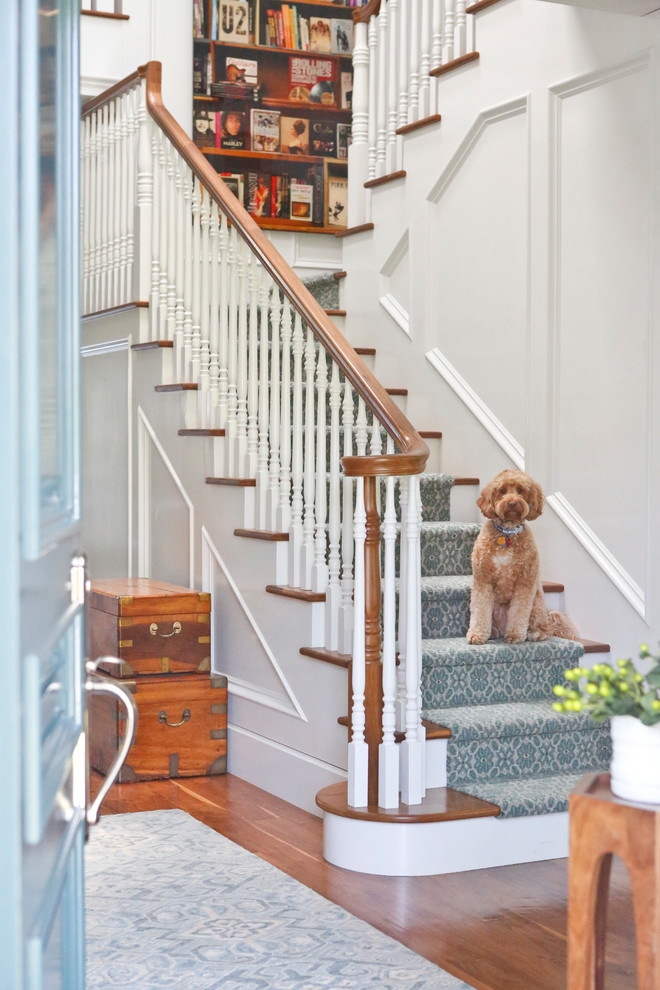 Design ideas for a mid-sized transitional carpeted l-shaped staircase in Los Angeles with carpet risers and wood railing.