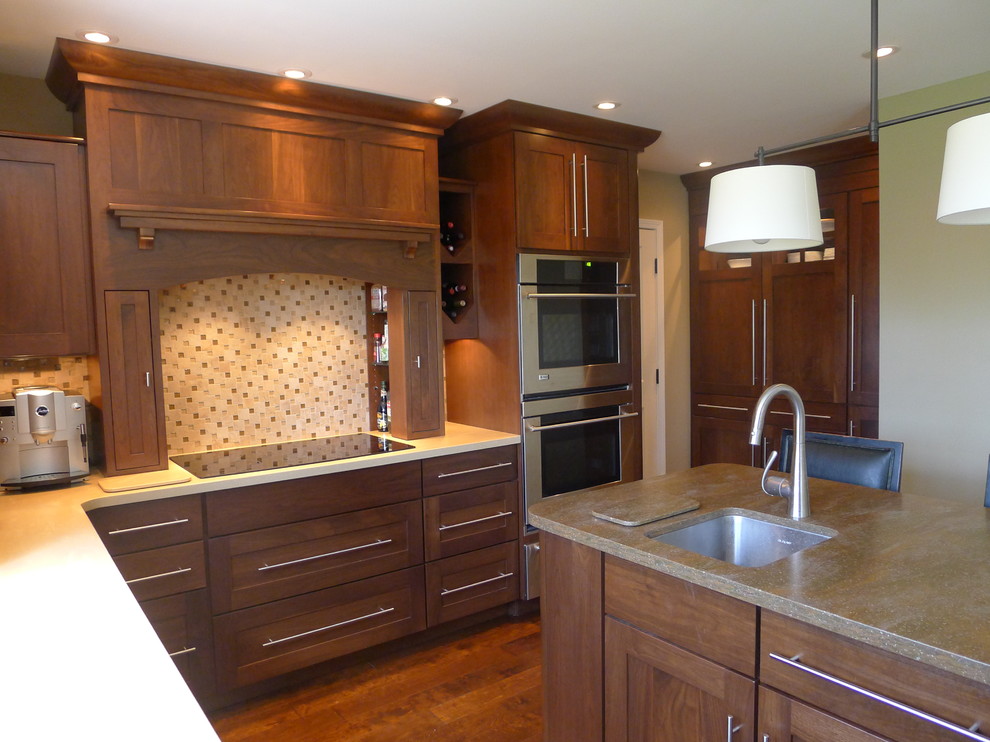 Design ideas for a traditional l-shaped eat-in kitchen in Indianapolis with an undermount sink, shaker cabinets, medium wood cabinets, solid surface benchtops, multi-coloured splashback and stainless steel appliances.