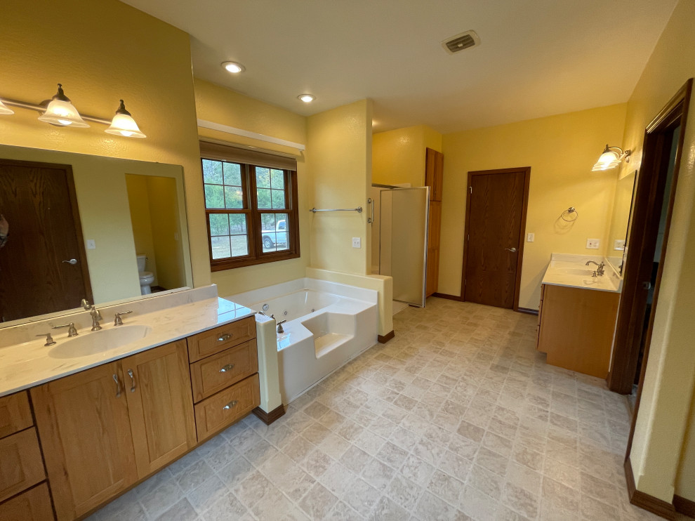 Пример оригинального дизайна: большая главная ванная комната в классическом стиле с фасадами в стиле шейкер, светлыми деревянными фасадами, ванной в нише, душем в нише, бежевой плиткой, желтыми стенами, полом из линолеума, столешницей из искусственного камня, разноцветным полом, душем с распашными дверями, бежевой столешницей, тумбой под одну раковину и встроенной тумбой