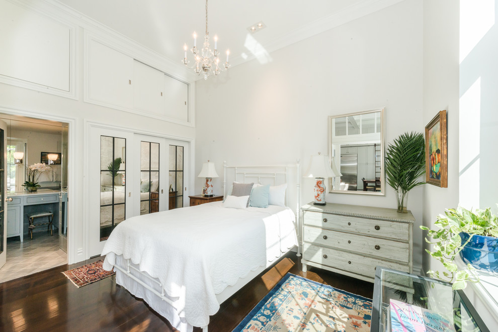 This is an example of a mid-sized country master bedroom in Boston with white walls, dark hardwood floors, no fireplace and brown floor.