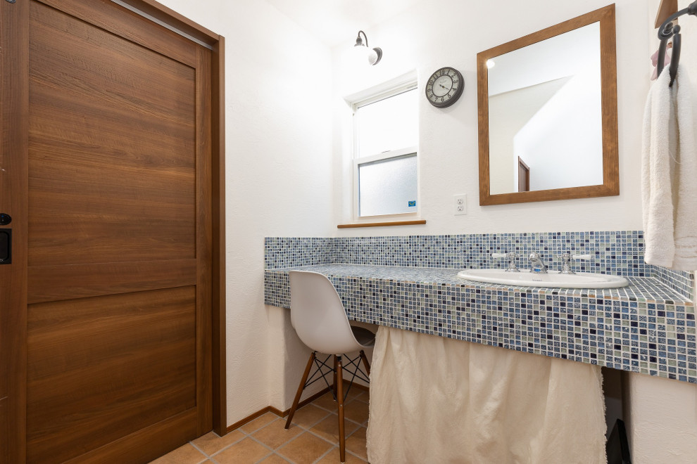 На фото: туалет с белыми стенами, коричневым полом и синей столешницей