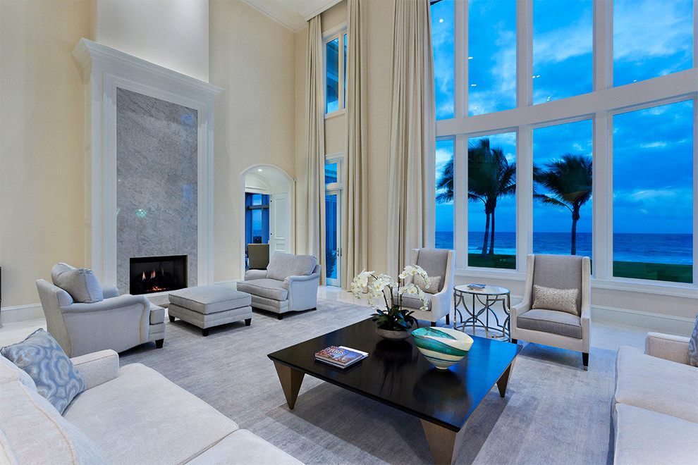 This is an example of a mid-sized transitional formal open concept living room in Miami with beige walls, marble floors, a standard fireplace, a stone fireplace surround, no tv and multi-coloured floor.