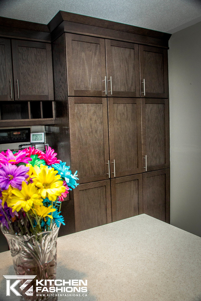 Enclosed kitchen - mid-sized transitional l-shaped enclosed kitchen idea in Toronto with an undermount sink, shaker cabinets, dark wood cabinets, quartz countertops, multicolored backsplash, subway tile backsplash, stainless steel appliances and an island