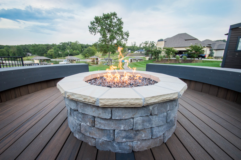 Example of a large transitional backyard deck design with a fire pit and no cover
