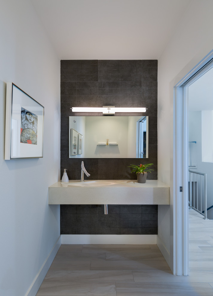 Design ideas for a mid-sized modern powder room in Tampa with gray tile, ceramic tile, white walls, vinyl floors, engineered quartz benchtops and beige benchtops.