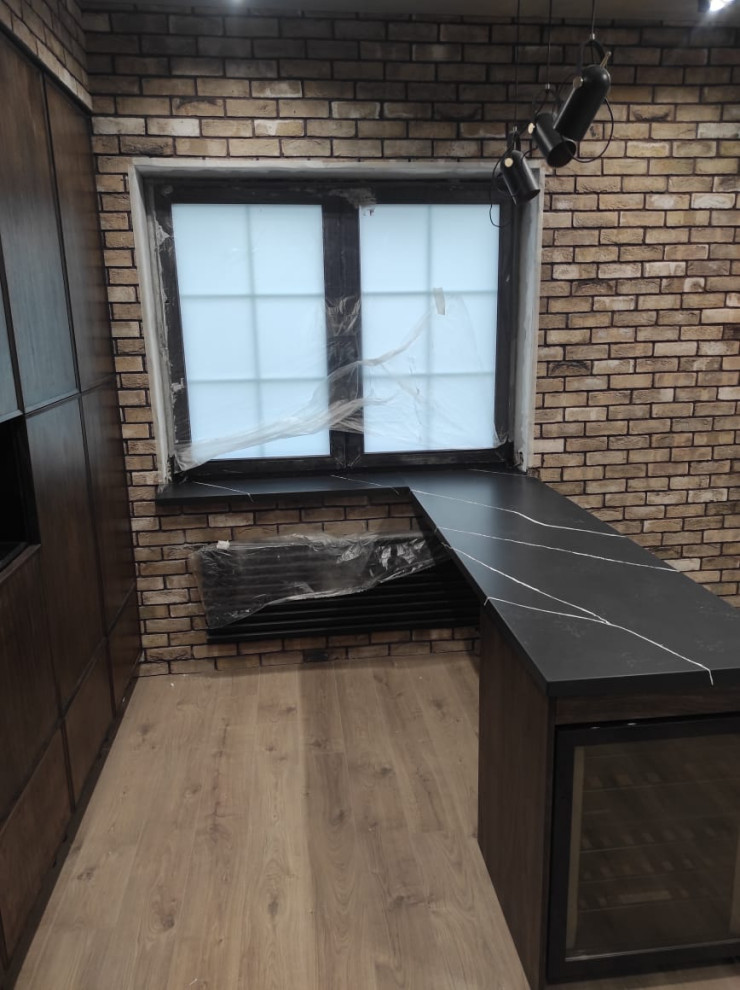 Photo of an industrial single-wall kitchen in Moscow with engineered stone countertops, black splashback, engineered quartz splashback, no island and black worktops.