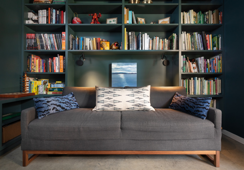 Idee per un piccolo soggiorno minimal con libreria, pareti verdi, pavimento in cemento e pavimento grigio