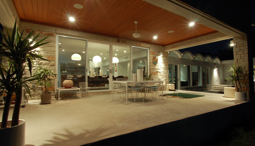 Inspiration for a modern patio in Austin with a roof extension.