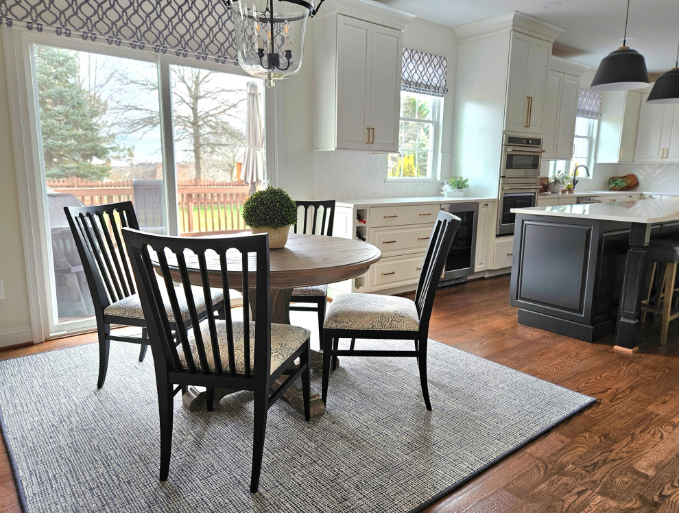Inspiration for a large transitional u-shaped medium tone wood floor eat-in kitchen remodel in DC Metro with white walls, an undermount sink, raised-panel cabinets, white cabinets, quartz countertops, white backsplash, ceramic backsplash, stainless steel appliances, an island and white countertops