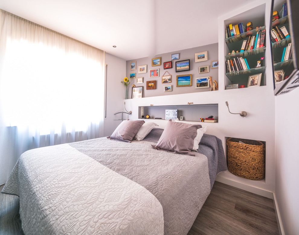 Modelo de dormitorio principal y gris y blanco mediterráneo de tamaño medio con paredes grises, suelo de madera en tonos medios y suelo gris