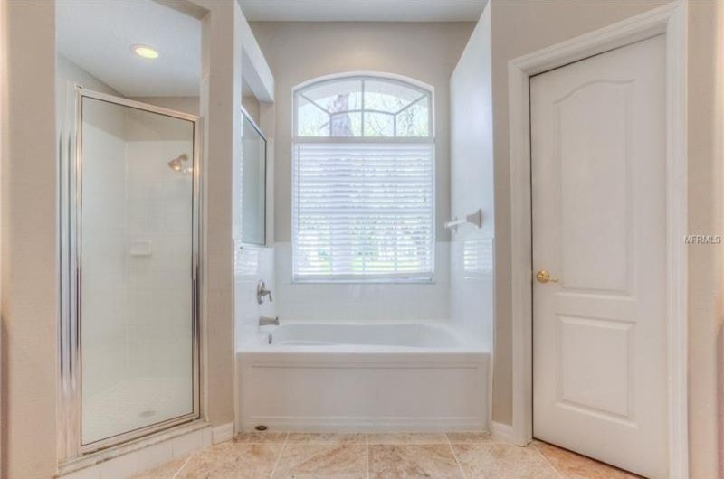 Design ideas for a mid-sized traditional master bathroom in San Diego with recessed-panel cabinets, dark wood cabinets, an alcove tub, a corner shower, ceramic tile, grey walls, ceramic floors, an undermount sink, granite benchtops, beige floor, a hinged shower door and multi-coloured benchtops.
