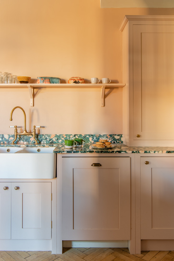 Exempel på ett stort flerfärgad linjärt flerfärgat kök med öppen planlösning, med en rustik diskho, skåp i shakerstil, bänkskiva i terrazo, integrerade vitvaror, en köksö och beiget golv