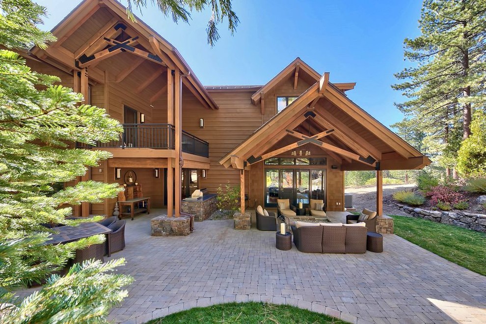Example of a large transitional backyard concrete paver patio kitchen design with a roof extension