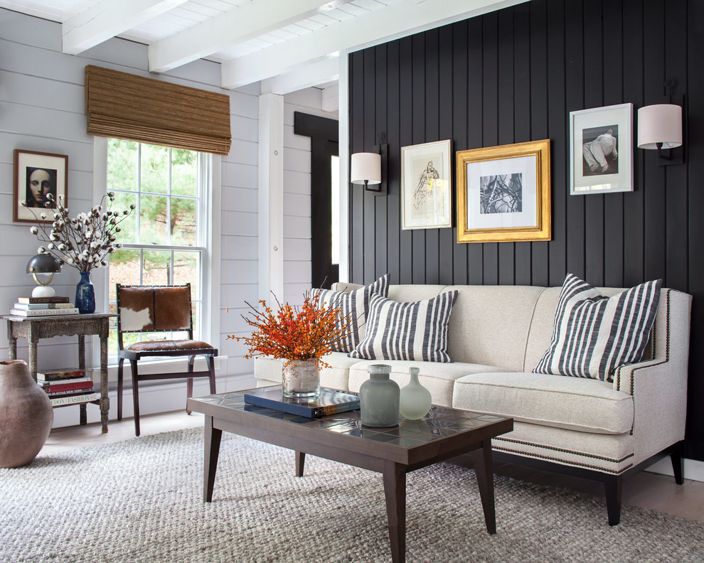 Photo of a country living room in New York with black walls, dark hardwood floors and brown floor.