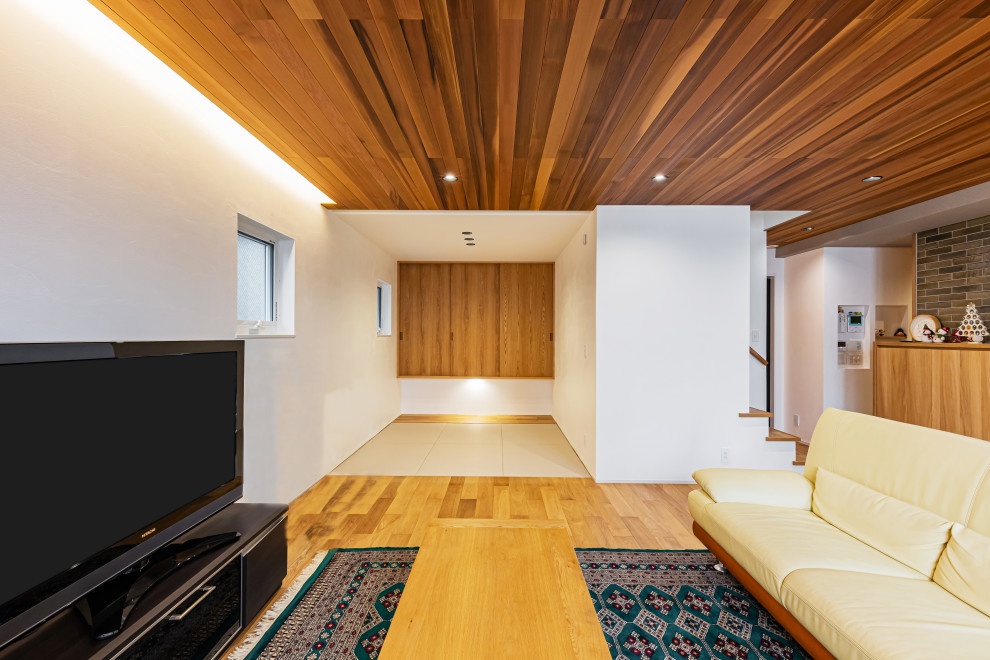 Diseño de salón abierto moderno grande con suelo de madera en tonos medios, televisor independiente, suelo marrón y madera
