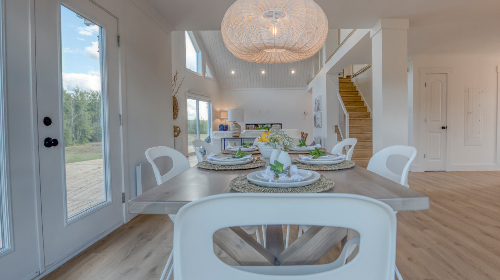 Idee per una grande sala da pranzo aperta verso la cucina stile marinaro con pareti bianche, pavimento in laminato e pavimento marrone