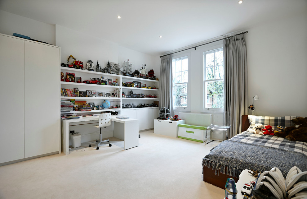 This is an example of a large contemporary kids' bedroom for kids 4-10 years old and boys in London with white walls and carpet.