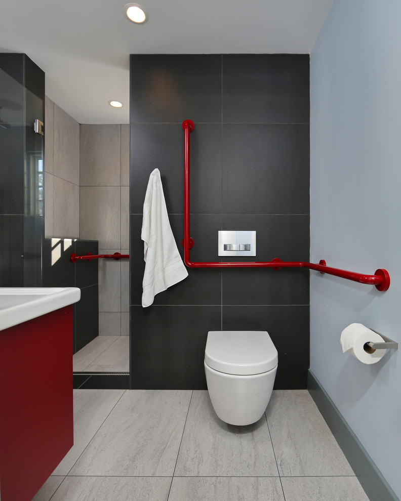 Photo of a small modern master bathroom in Boston with a wall-mount sink, flat-panel cabinets, red cabinets, a wall-mount toilet, black tile, porcelain tile, black walls and porcelain floors.
