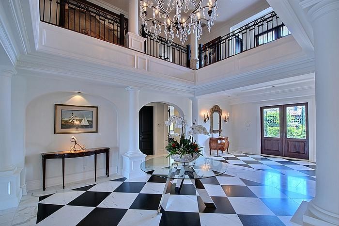 Expansive mediterranean foyer in Miami with white walls, marble floors, a double front door and a dark wood front door.