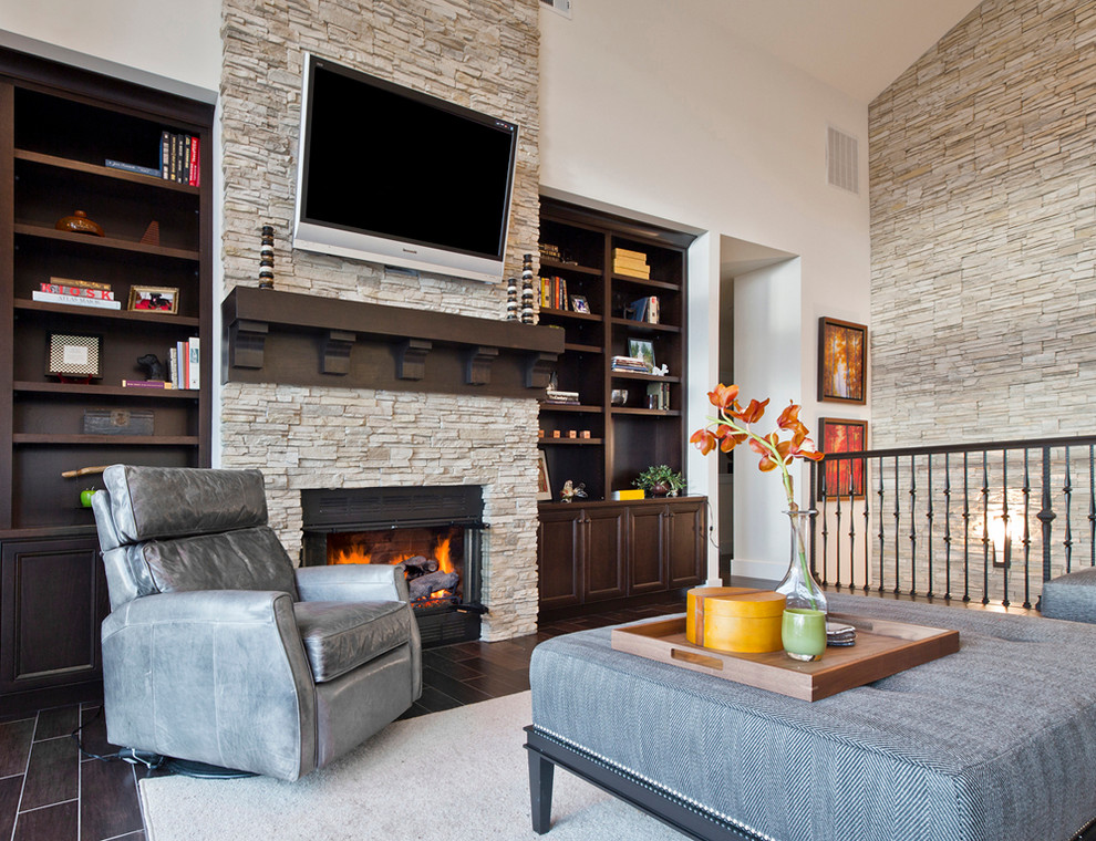 Photo of a mid-sized transitional loft-style living room in Seattle with a stone fireplace surround, white walls, dark hardwood floors, a standard fireplace, a wall-mounted tv and brown floor.